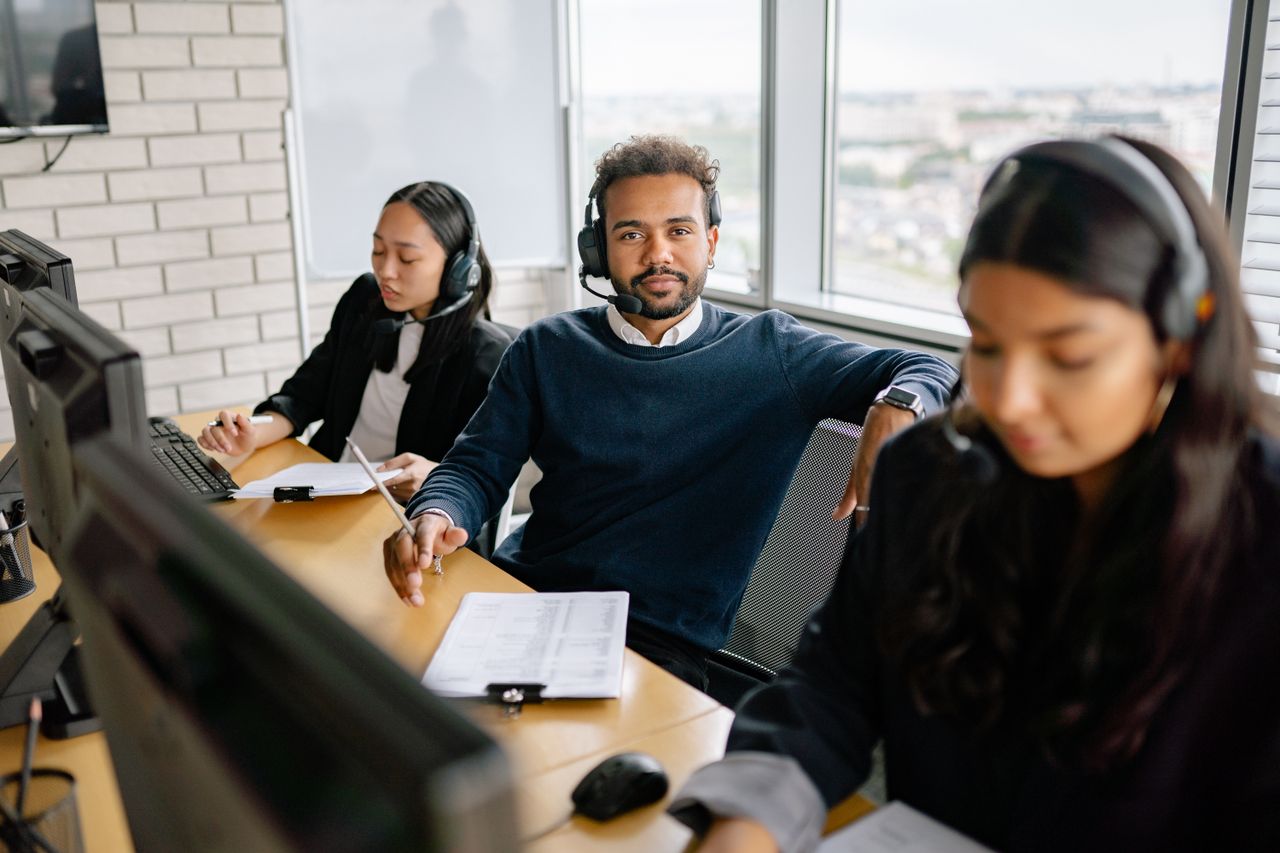 A focused call center team attending customer calls in a modern office setting.